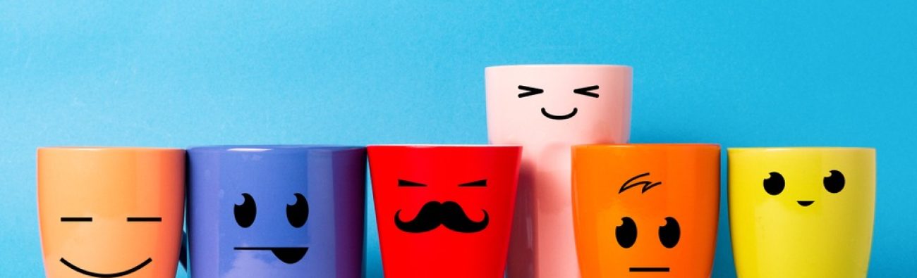 A,Lot,Of,Multi-colored,Cups,With,Funny,Faces,On,A