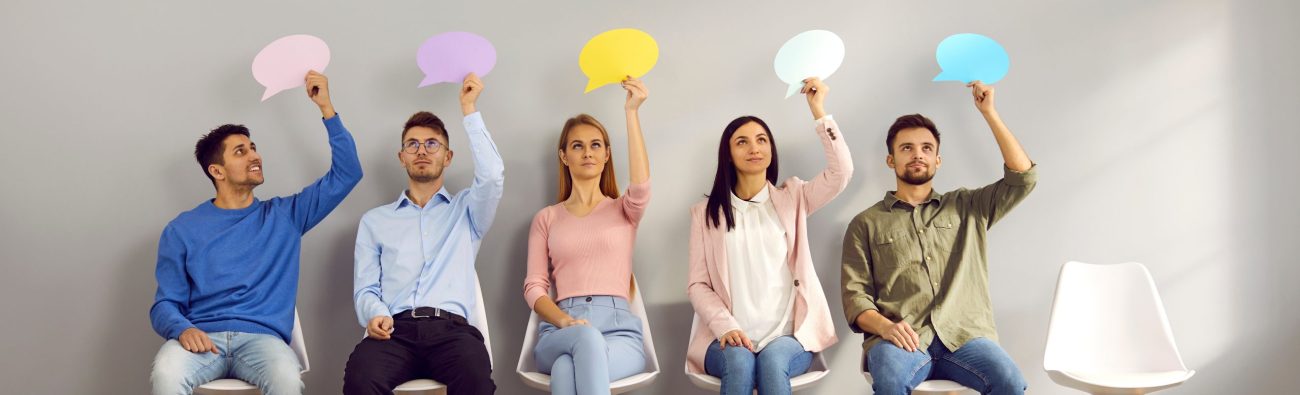 Group,Of,People,Sitting,On,Row,Of,Chairs,,Thinking,About