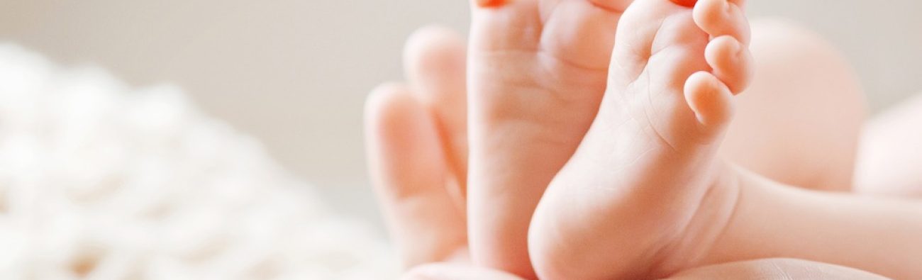 Baby,Feet,In,Mother,Hands.,Mom,And,Her,Child.,Happy